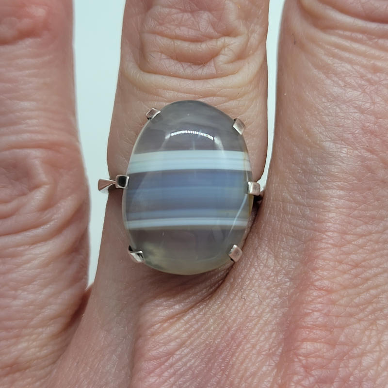 Silver Oval Striped White Agate Ring A large oval striped polished pale-coloured and banded agate ring all claw set in 925 silver. The agate measures 1.8cm x 1.4cm UK Size L½ US Size 6 Circumference 52mm