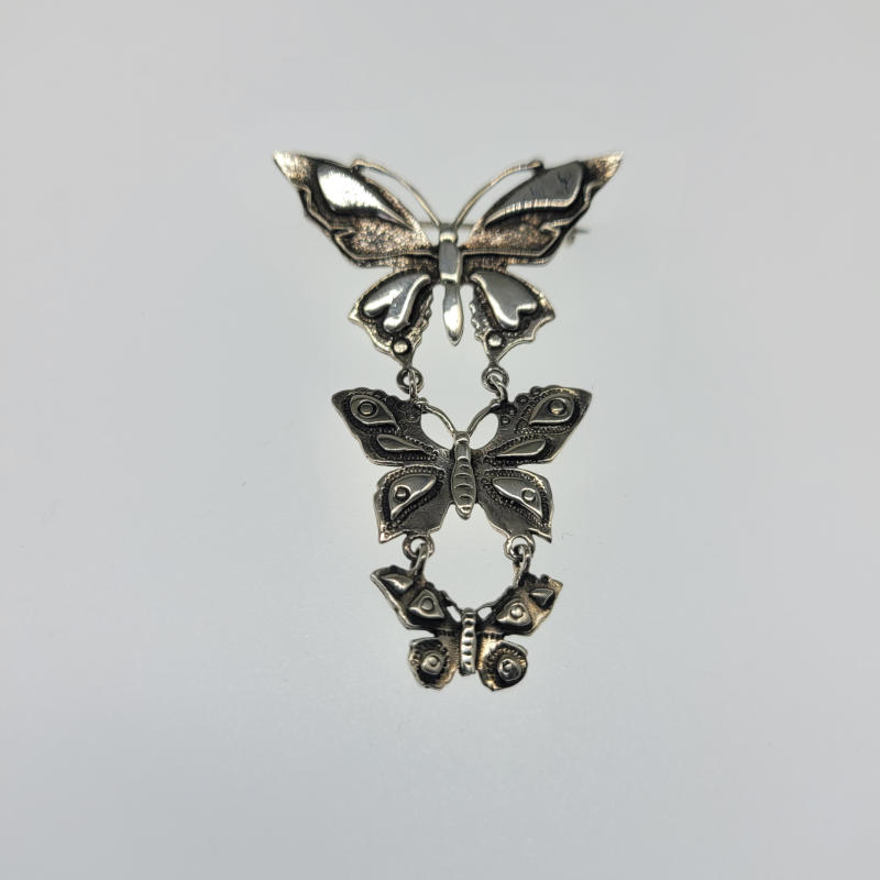 Silver Triple Drop Butterfly Brooch A distinctive and unusual brooch with three different sized 925 silver butterflies hanging below each other and decreasing in size. Measures 3.6cm x 5.3cm