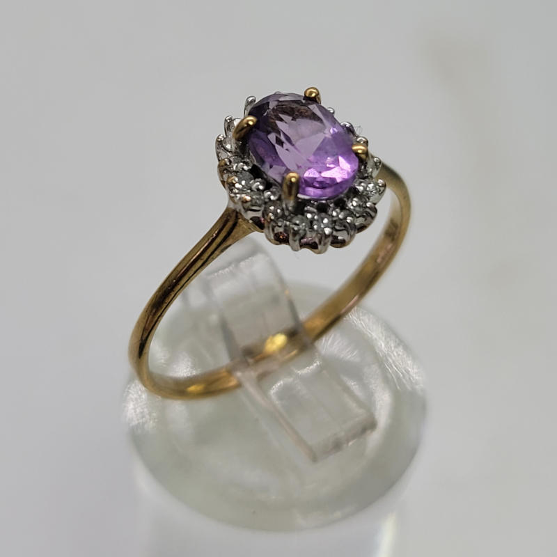 9ct 1K Oval Amethyst and Diamond Ring A gorgeous and extremely sparkly 9ct yellow gold ring with an oval amethyst of approximately 1K surrounded by diamonds. Hallmarked Birmingham 1989 UK SIZE P US SIZE 7¾ Circumference 56mm