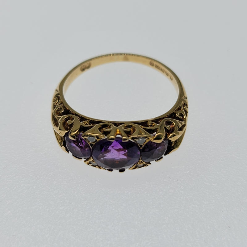 Ornate 9ct Amethyst Trilogy and Diamond Ring A gorgeous 9ct yellow gold ring which is very ornate in design. It has 3 very purple round amethyst stones which graduate in size with the largest being in the centre of the ring. It also has 4 small diamonds which just increase the sparkle. Hallmarked London 1973 UK Size J½ US Size 5 Circumference 49.5mm