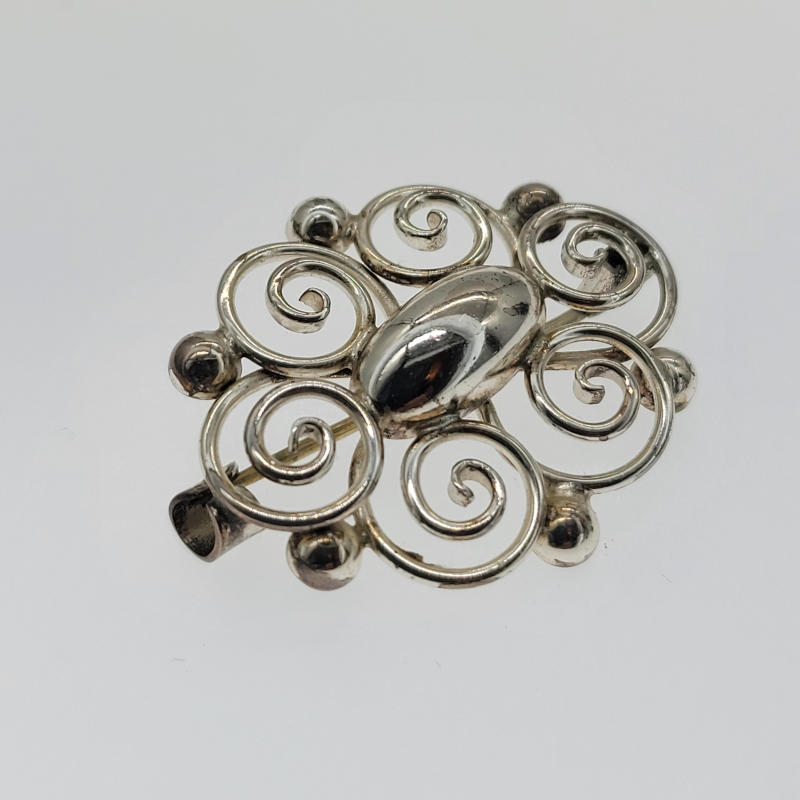 Danish Silver Brooch by Hermann Siersbol A vintage brooch made in 925 silver and hallmarked as from Denmark by Hermann Siersbol. The brooch is oval and is made up of swirls which raise up and out from where they start. It measures 3.3cm in width and is 2.8cm high